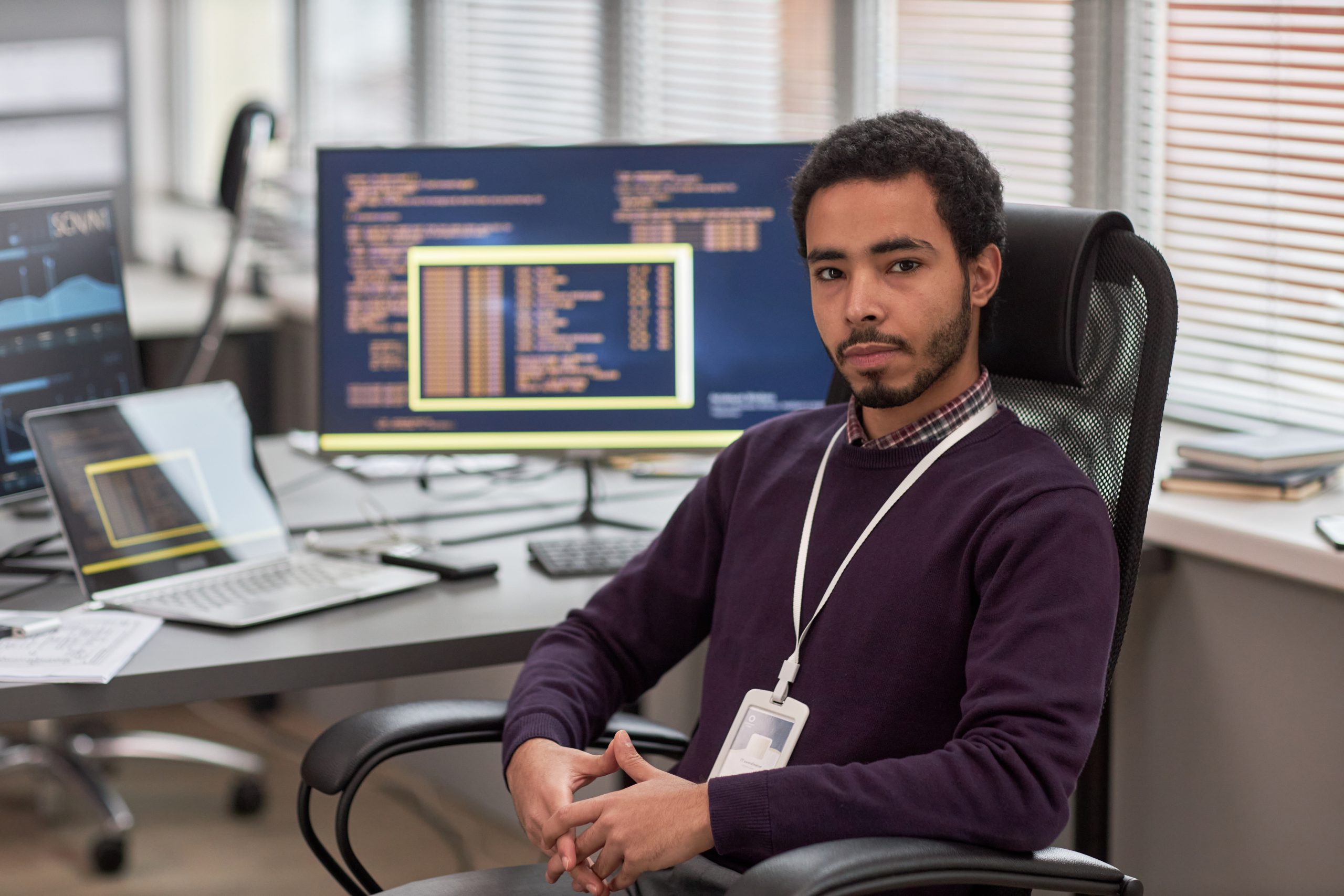a man sitting at his computer facing us as part of his career in medical coding