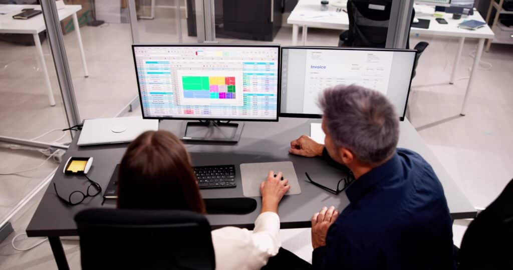 medical billing professional and medical coder working side by side at computer workstations in a healthcare office