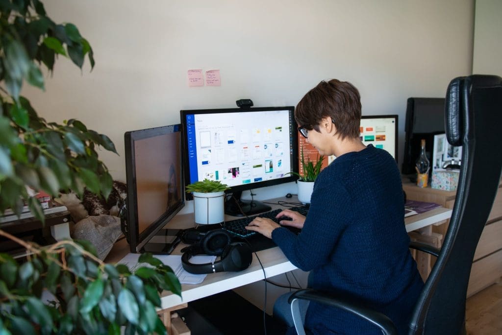woman with glasses at her computer typing as part of her career in medical billing